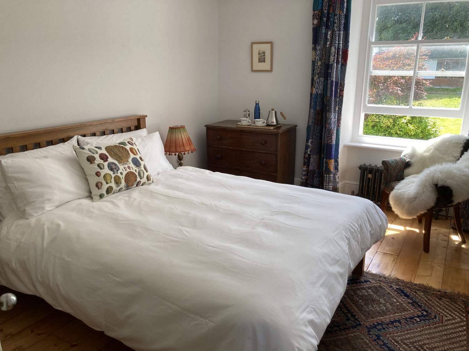 Image showing large double bedroom, white bed covers and a view to the garden.