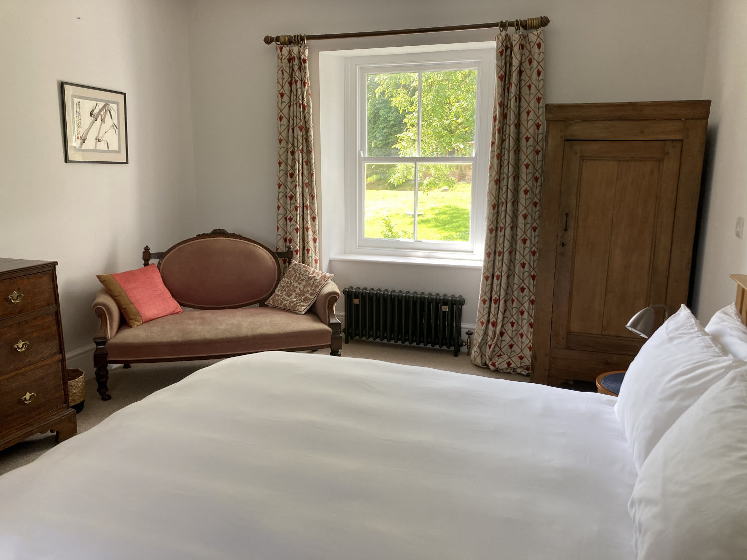 Image showing large double bedroom, white bed covers, other furniture and a view to the garden.